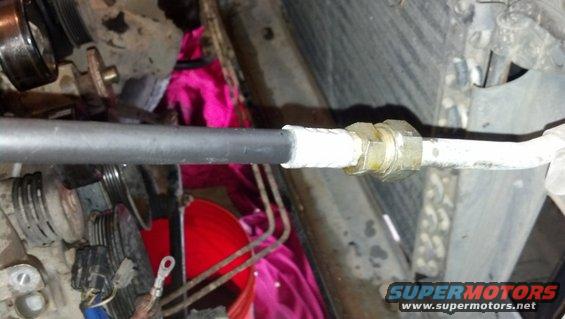 Close-up of a metal hose connection with white tape