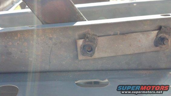 Close-up of a metal bracket with a bolt on a vehicle frame