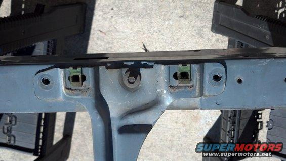 close-up of a vehicle's gray metal frame section with green plastic clips