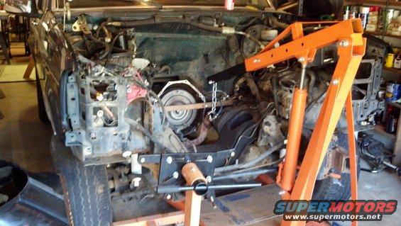 1993 Ford Bronco engine bay with transmission removed and engine hoist supporting drivetrain