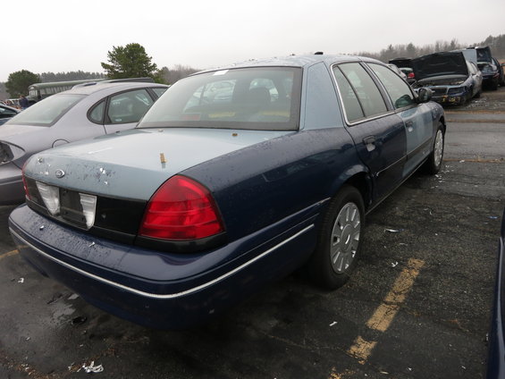 Dark blue and light blue Ford Crown Victoria, rear quarter view, showing damage and mismatched paint panels