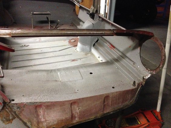 Interior floor pan of a car undergoing restoration, showing bare metal and some rust