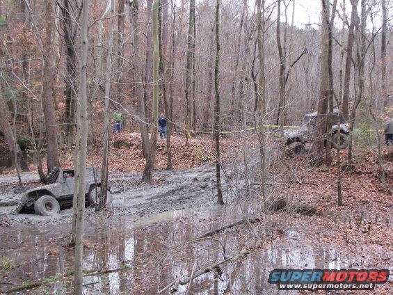 Off-road vehicles stuck in mud in a wooded area