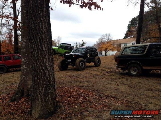 Black and tan Ford Bronco parked on a dirt hill