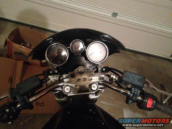 Motorcycle handlebars with gauges, brake reservoir, and controls visible