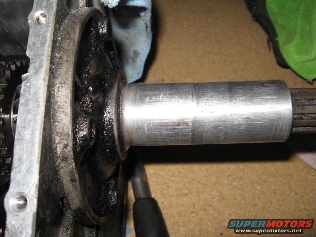 Close-up of a greasy automotive part with a splined shaft extending from a metal housing