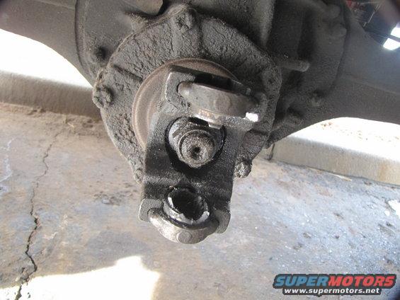 Broken and greasy u-joint caps on the axle.