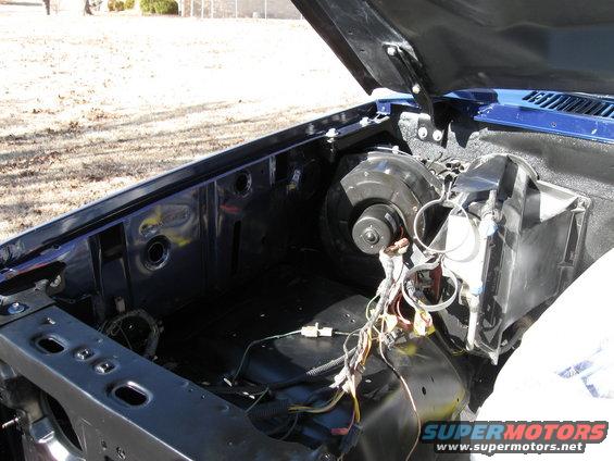 Engine bay of a vehicle, hood open. Looks like a V8 engine