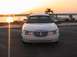 2002 Lincoln Town Car - A white 2002 Lincoln Town Car is parked near the water with a sunset in the background.