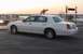 2002 Lincoln Town Car - A white 2002 Lincoln Town Car is seen from the side near a marina with boats in the background.
