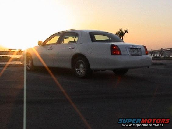 2002 Lincoln Town Car parked near water at sunset