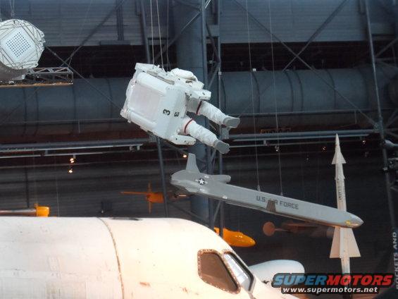 Space suit hanging above a U.S. Air Force aircraft and part of a space shuttle