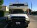 1997 Dodge 3500 - A white Dodge Ram pickup truck with a Lance camper shell is parked on a residential street.