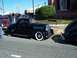 1971 Ford Ranchero - A black coupe from the mid-1930s is parked next to another vehicle on a sunny day.