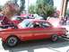 1971 Ford Ranchero - A red classic car, likely a Ford Falcon, is displayed with its hood open at an outdoor event.