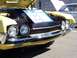 1971 Ford Ranchero - This yellow pickup truck, likely a 1970 model, is displayed with its hood open and a sign clarifying it is not a Torino.