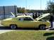 1971 Ford Ranchero - A yellow 1970 Ford Falcon is displayed with its hood open, drawing attention from onlookers.