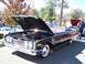 1971 Ford Ranchero - A black convertible with its hood open, revealing the engine. The vehicle has whitewall tires and is seen at an outdoor event.