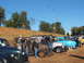 1971 Ford Ranchero - A group of men gather around a collection of classic vehicles on a sunny day.