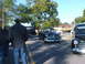 1971 Ford Ranchero - A black 1949 Ford sedan is parked on a street, with other vehicles and people visible in the background.