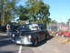 1971 Ford Ranchero - A black sedan from 1948 is parked on the street, with other vehicles and equipment visible in the background.