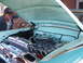 1971 Ford Ranchero - A man inspects the polished engine of a vintage automobile, with the hood open.