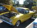 1971 Ford Ranchero - A yellow pickup truck is parked outside with its hood up, revealing the engine compartment.