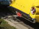 1971 Ford Ranchero - A close-up view of the rear of a yellow vehicle, a chrome bumper and a red license plate.