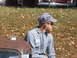 1971 Ford Ranchero - A man in work attire sits outdoors near a rusty vehicle part, with another car visible in the background.