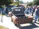 1971 Ford Ranchero - A weathered pickup truck, likely from the 1950s, is displayed with its engine exposed, drawing a crowd of onlookers.