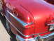 1971 Ford Ranchero - Close-up of a vintage red car's rear end, showing chrome accents and a tail light assembly.
