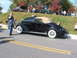 1971 Ford Ranchero - A classic black convertible is displayed at an outdoor event with other vehicles and spectators present.