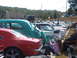1971 Ford Ranchero - A gathering of classic cars is parked in a lot, with spectators observing the vehicles.
