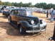 1971 Ford Ranchero - A classic black sedan is displayed at an outdoor event with other vehicles and attendees present.
