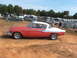 1971 Ford Ranchero - Side view of a red and white Studebaker Hawk coupe at an outdoor event with RVs in the background.