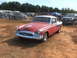 1971 Ford Ranchero - A classic red and white coupe with a distinctive grille and chrome accents is parked outdoors.