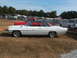 1971 Ford Ranchero - A classic white convertible coupe is parked in a grassy area with several RVs and trucks in the background.