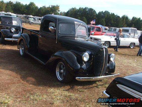 Black 1937 Ford pickup truck, 3q front view, with custom wheels