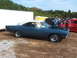 1971 Ford Ranchero - A blue coupe with a white roof is parked outdoors with its hood open, while people gather around.