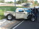 1971 Ford Ranchero - A custom pickup truck with an exposed engine and large rear wheels is parked next to another vehicle.