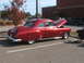1971 Ford Ranchero - A classic red coupe is parked with its hood open, alongside a black pickup truck.