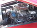 1971 Ford Ranchero - The engine bay of a red vehicle displays a V8 engine with aftermarket components.