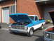 1971 Ford Ranchero - A blue and white pickup truck is parked with its hood open, showing the engine bay.