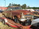 1971 Ford Ranchero - This heavily rusted coupe, likely from the 1950s, is being transported on a trailer.
