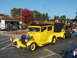 1971 Ford Ranchero - A yellow 1928 Ford Model A sedan is parked with a trailer, with people near a food truck in the background.