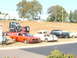 1971 Ford Ranchero - An orange muscle car is parked on a grassy area next to a semi-truck and other vintage vehicles.