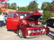 1971 Ford Ranchero - Custom red pickup truck on display, showing off its engine and chrome details.