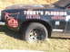 1971 Ford Ranchero - Side view of a black vehicle with plumbing company advertising and phone numbers visible.