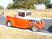 1971 Ford Ranchero - A customized vintage pickup truck is parked on the side of the road with a grassy embankment behind it.