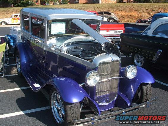 Purple and silver sedan hot rod with hood open, chrome grille, and custom wheels